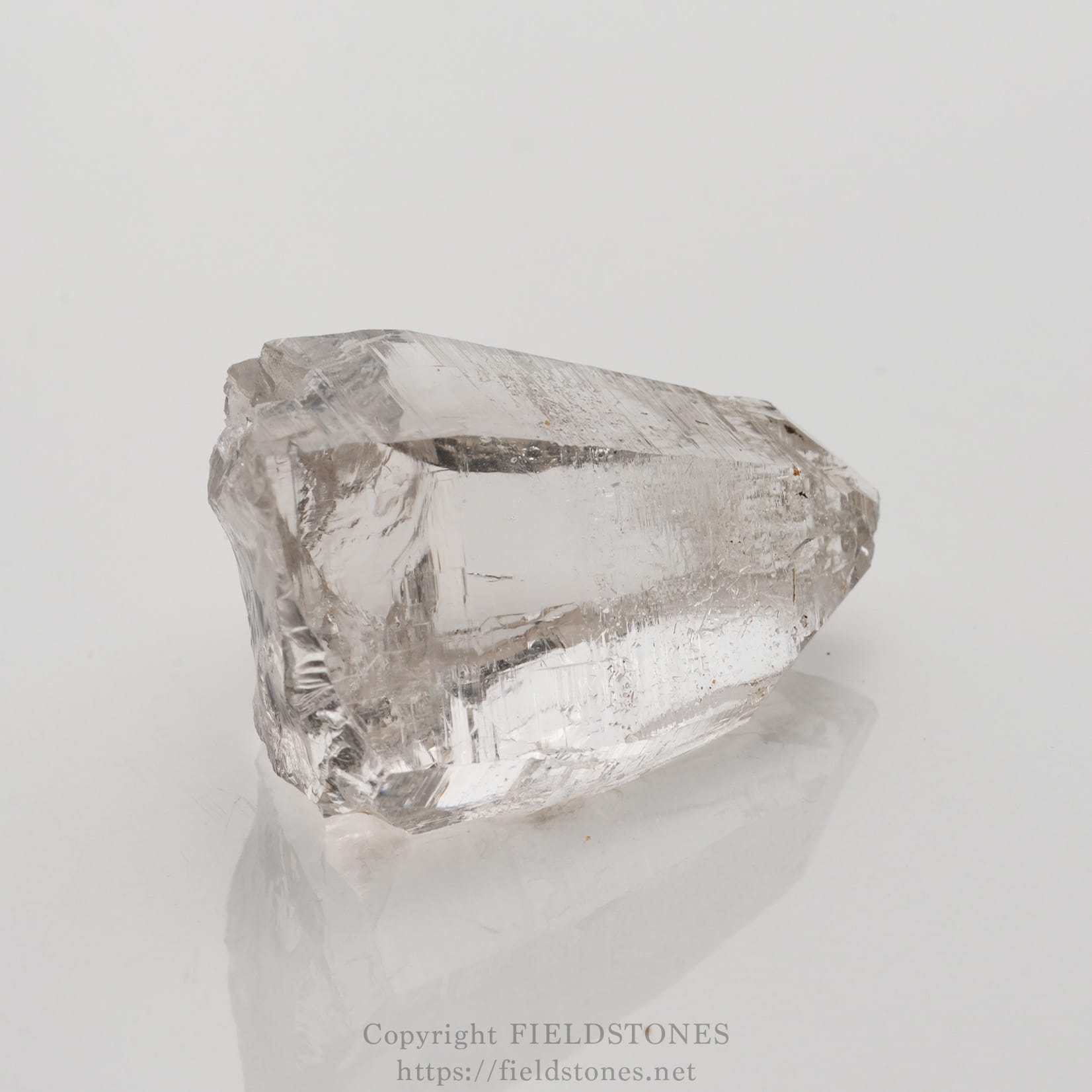 6509-3 - FieldStones Clear quartz crystal on a white background, showing its transparent, faceted structure and natural inclusions.