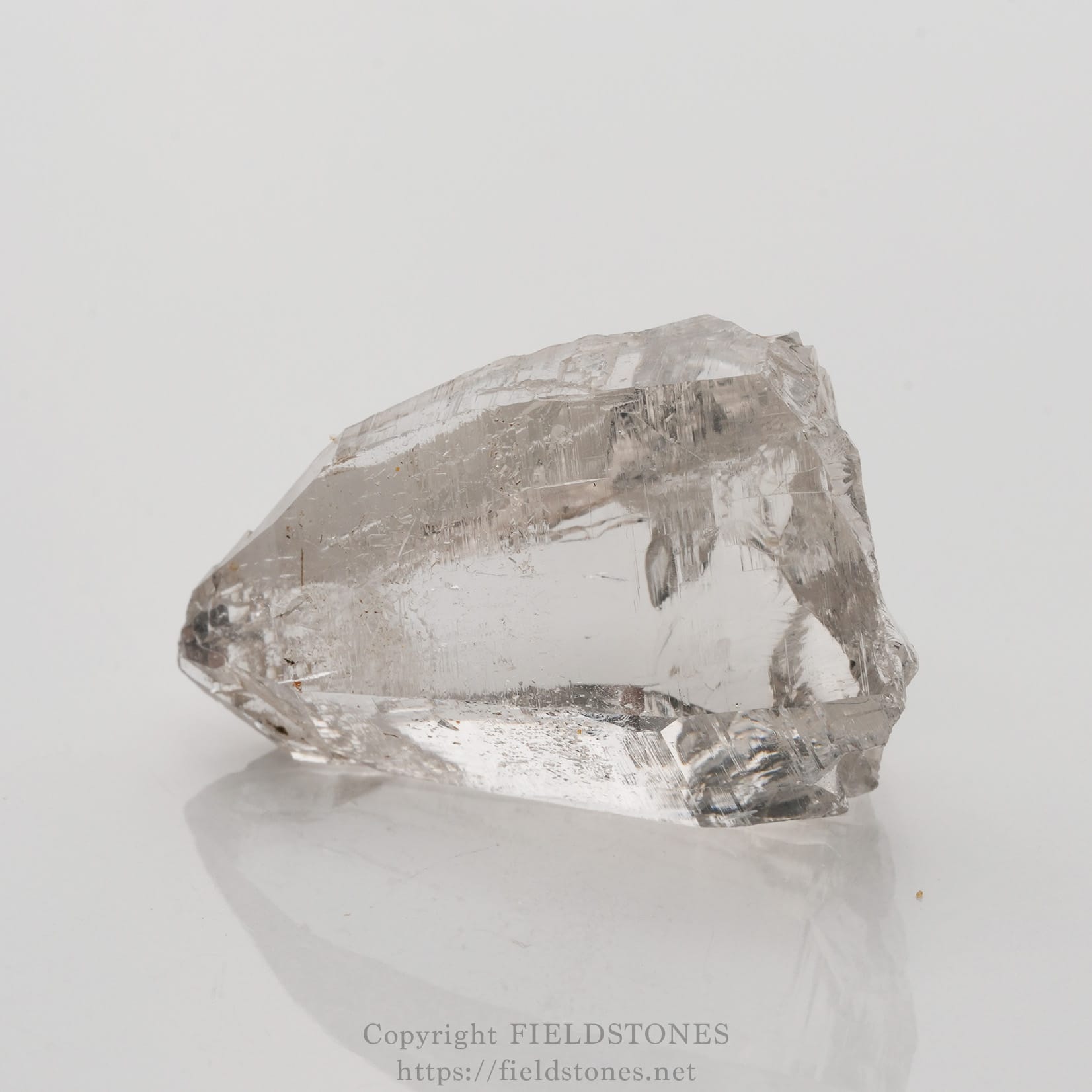 6509-7 - FieldStones Clear quartz crystal specimen with rough, faceted surface on a white background
