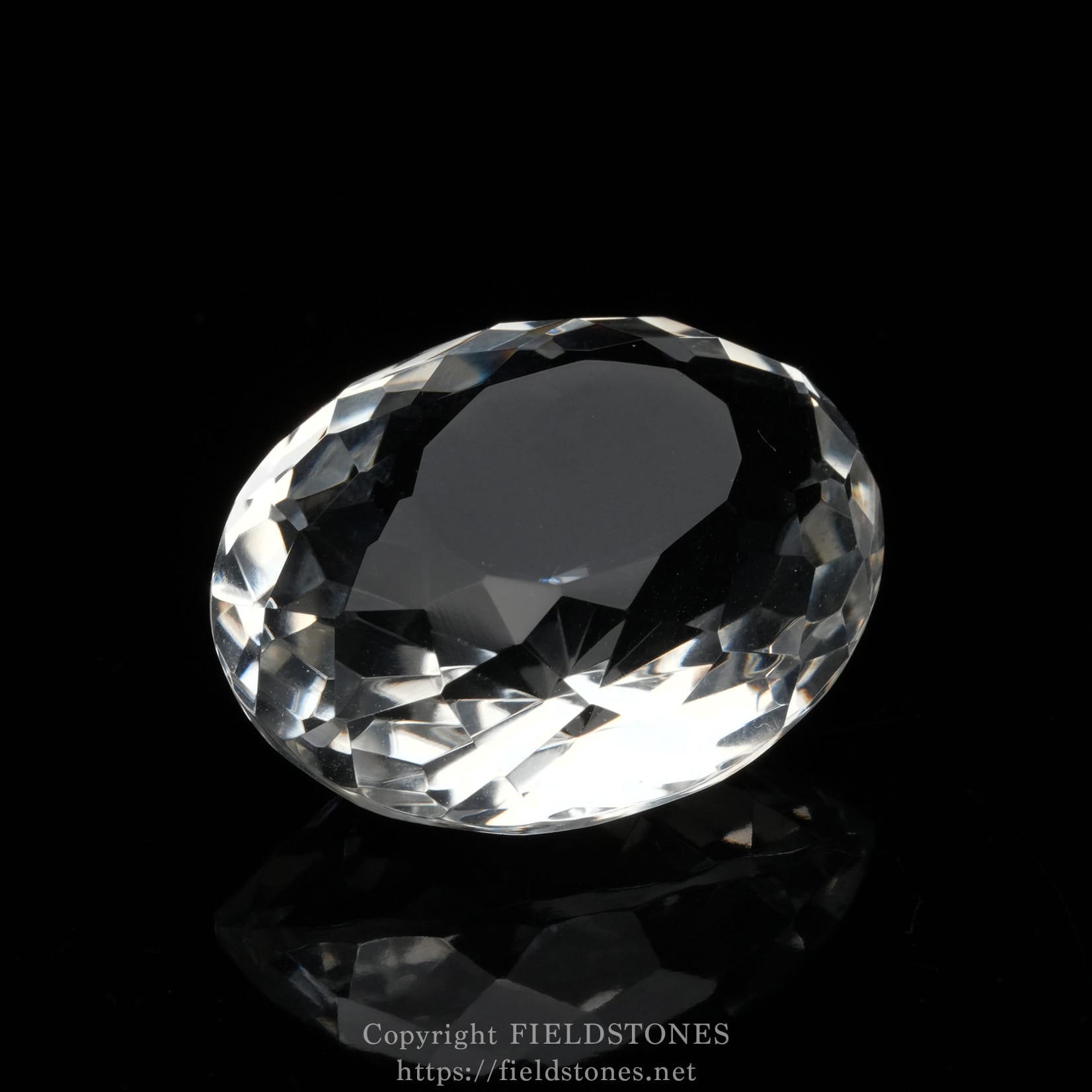 6537-9 - FieldStones Close-up of a faceted diamond on a black background, showing its many triangular facets and reflective surface.