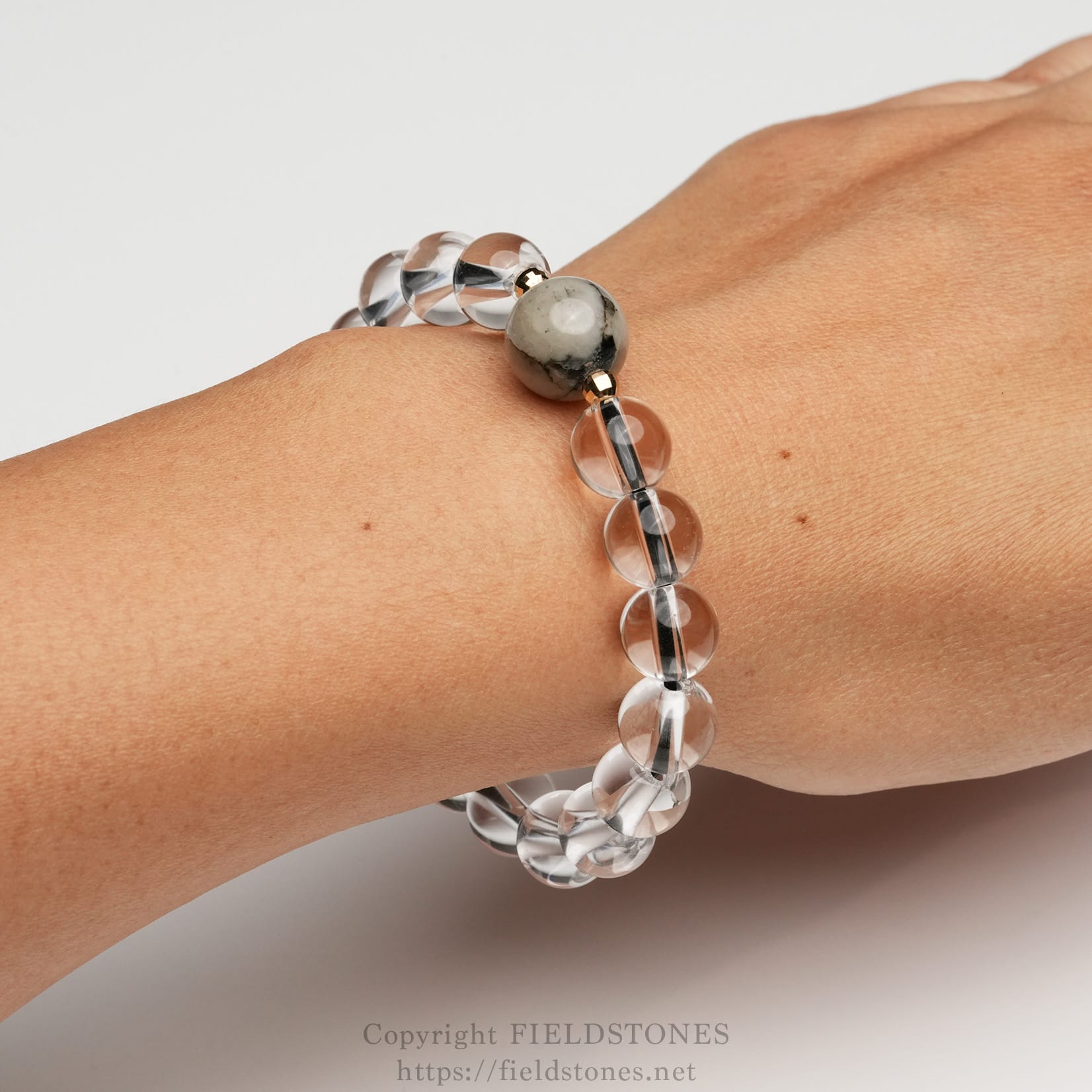 6547-10 - FieldStones Beaded bracelet on the wrist featuring a large gray marbled bead and clear glass beads.