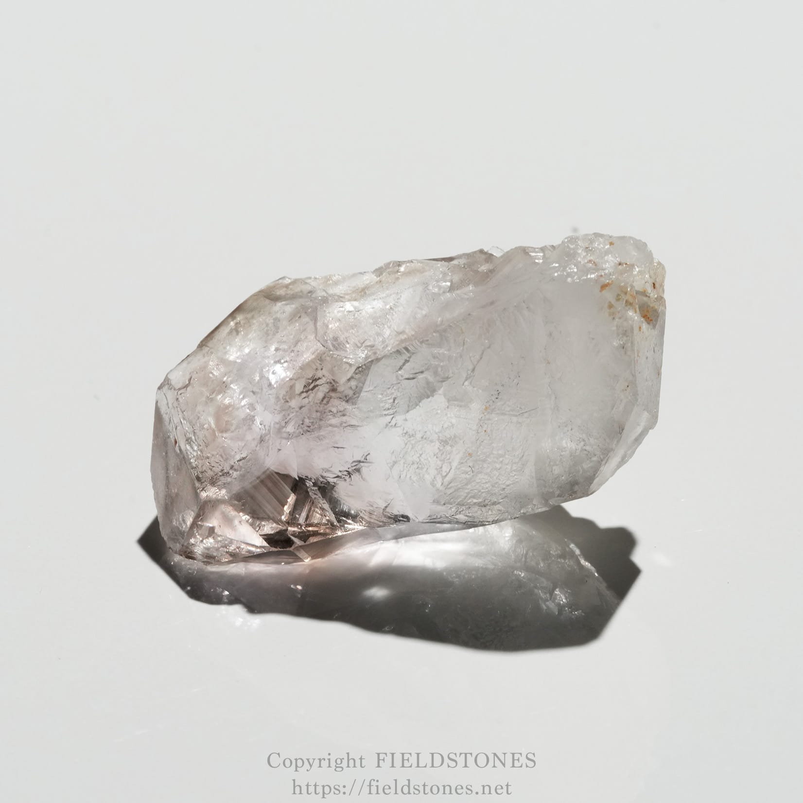 6562-6 - FieldStones Clear quartz crystal on a white background, casting a soft shadow to the left/underneath.