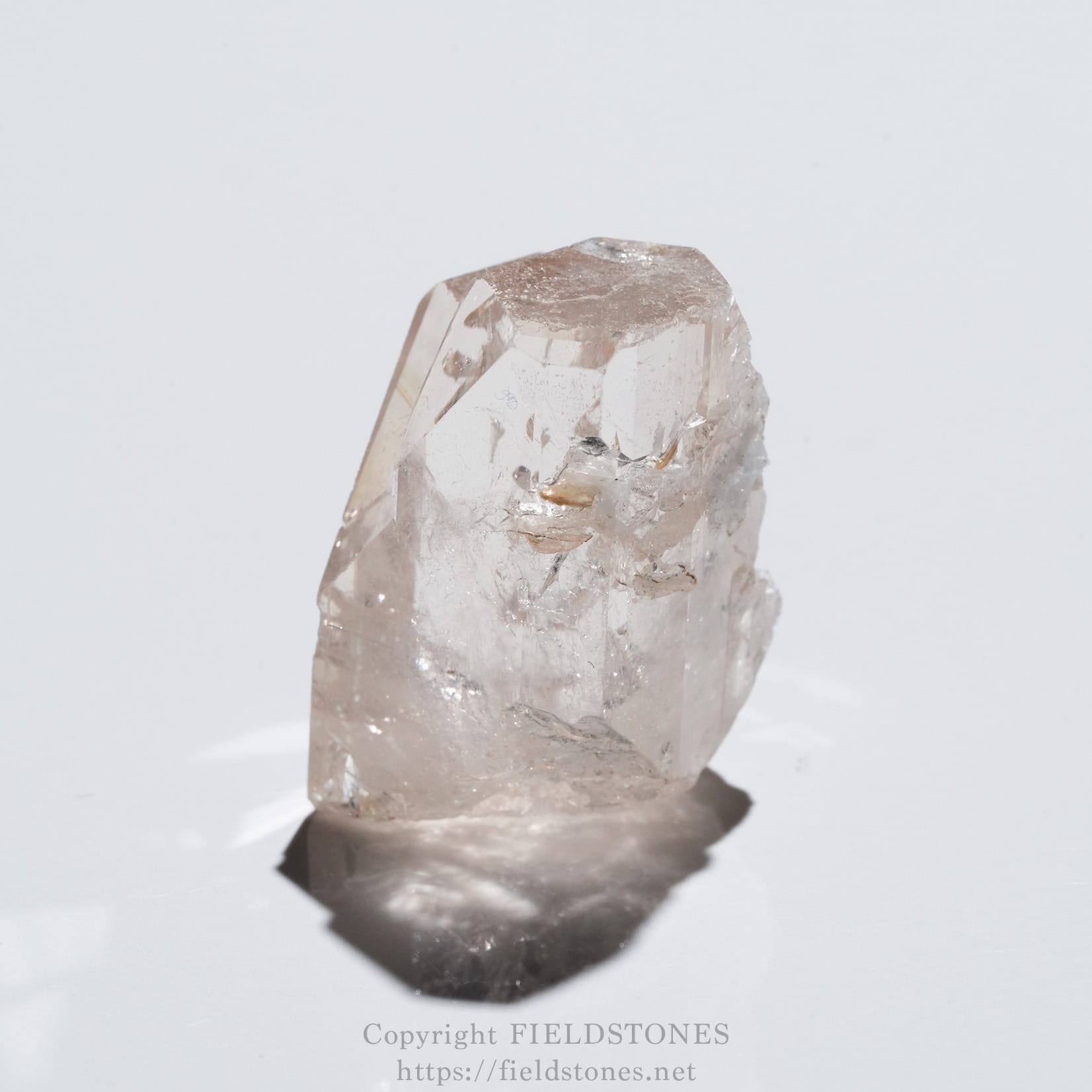 6576-11 - FieldStones Pink translucent quartz crystal specimen standing upright on a white surface.