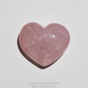 Polished pink rose quartz heart on a white background, smooth and glossy surface.