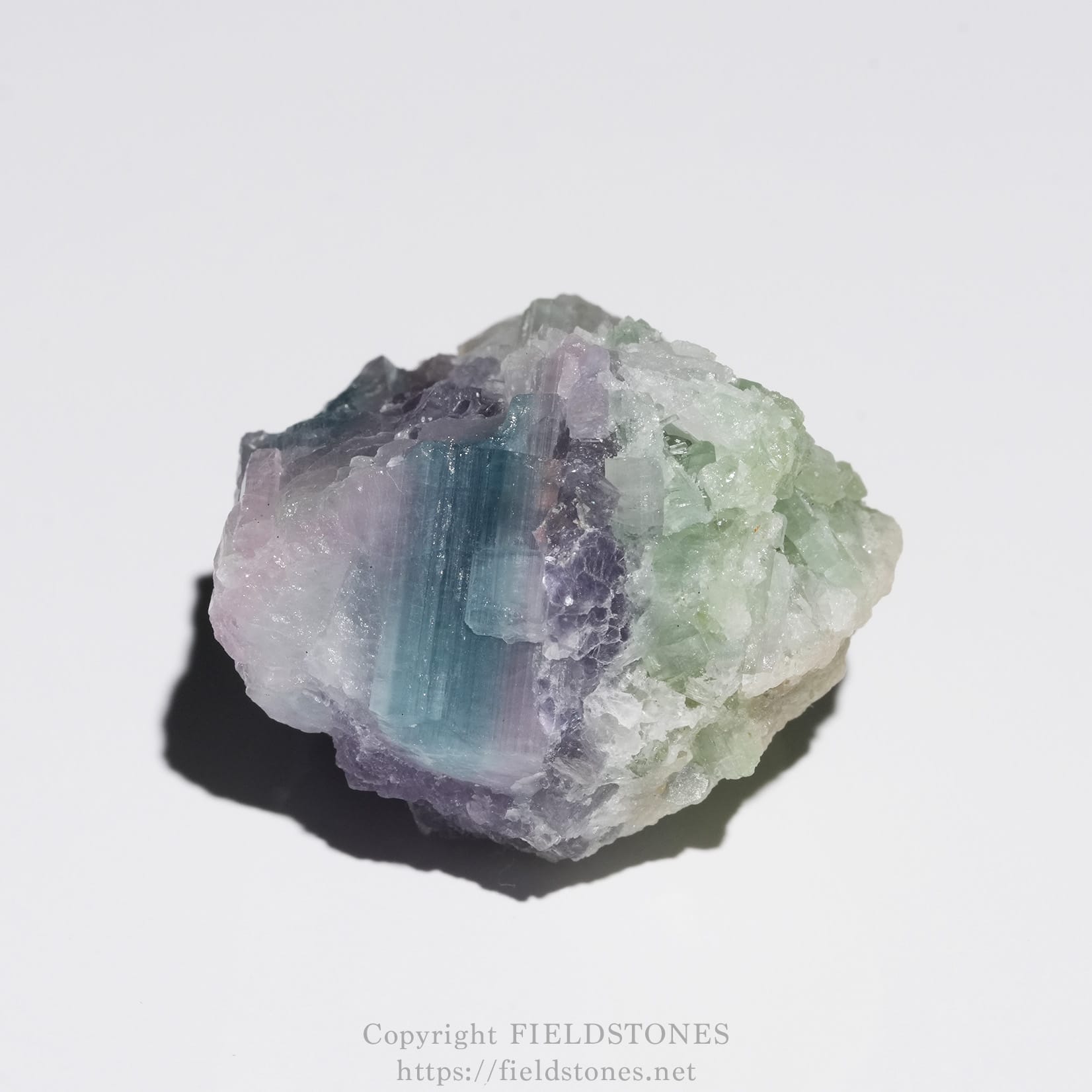 6645-4 - FieldStones Rough fluorite crystal cluster with purple, blue, and green bands on a white background.