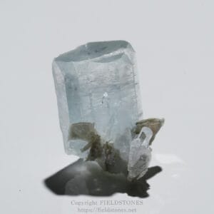 Pale blue aquamarine crystal on a rocky base against a white background.