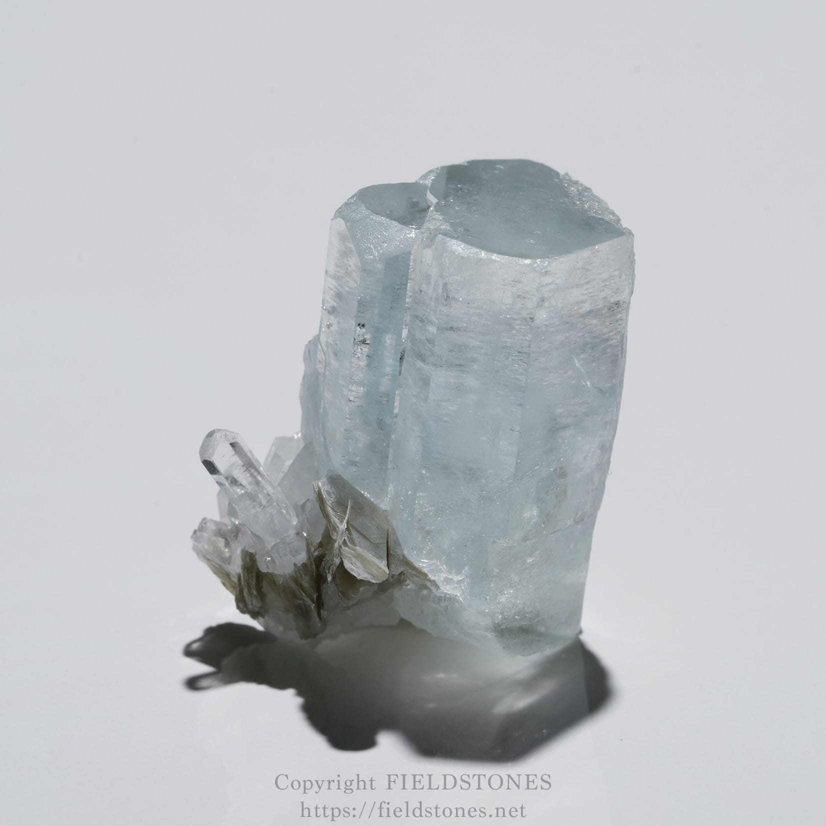 6690-3 - FieldStones Aquamarine crystal cluster with pale blue translucent prisms and jagged edges, resting on a reflective surface.