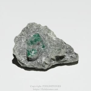 Gray rocky mineral with a green emerald crystal embedded in the center.