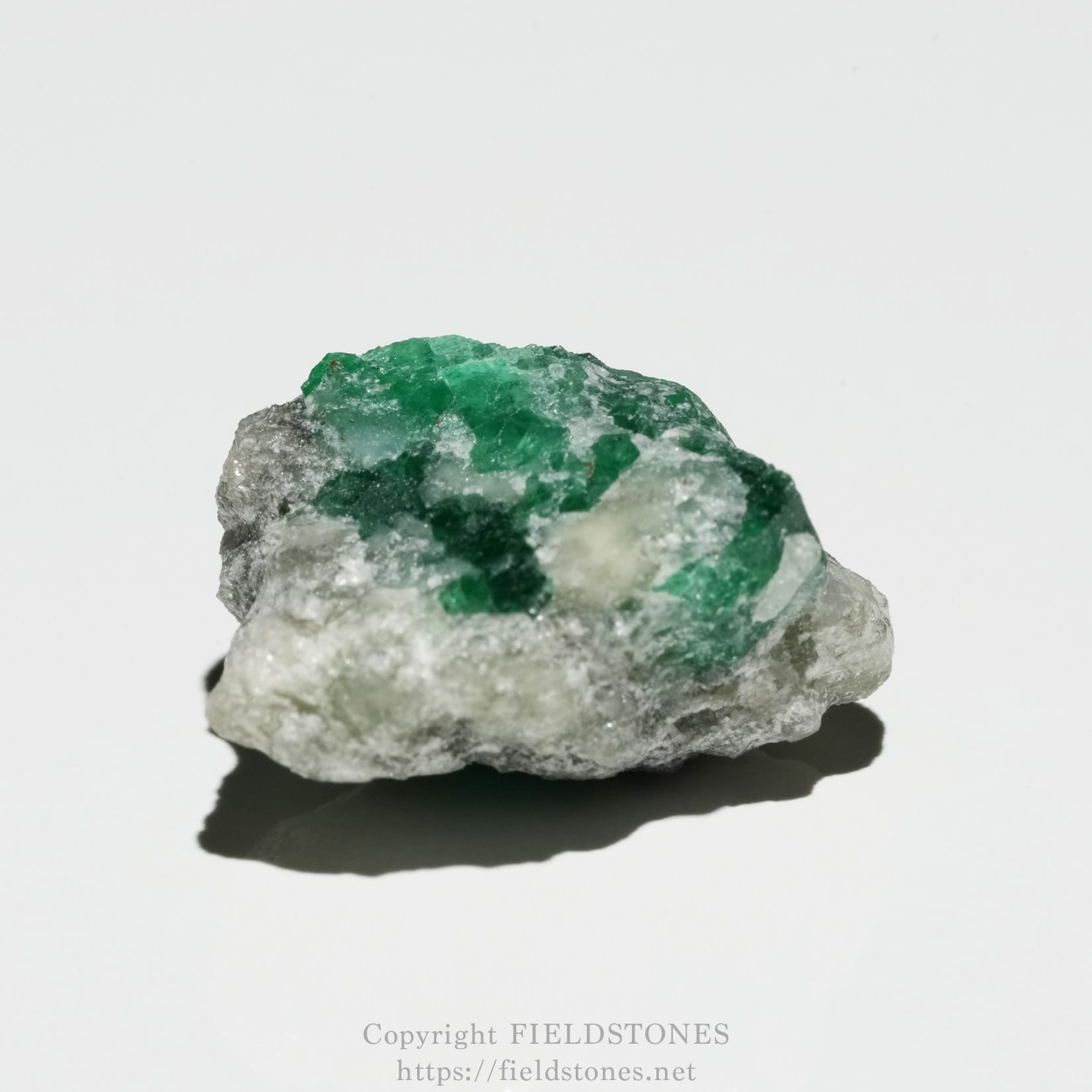 6700-6 - FieldStones Rough rock specimen with bright green emerald crystals growing on a gray matrix.