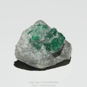 Rough gray rock with bright green crystal clusters embedded on one side, placed on a white background