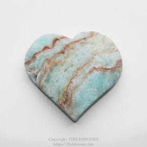Heart-shaped turquoise marble stone with copper-brown veins on a light background.