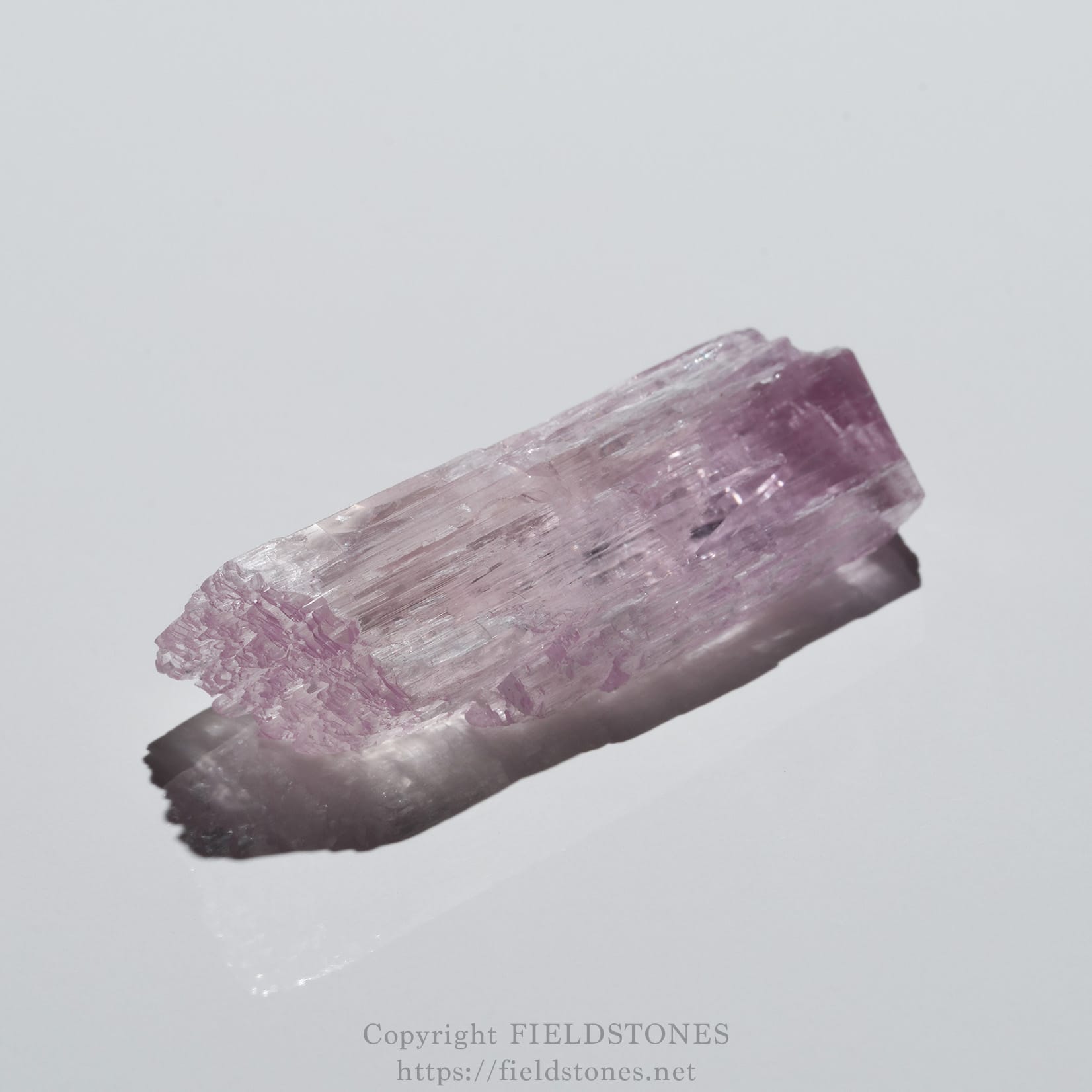 6726-1 - FieldStones Pinkish-purple amethyst crystal set against a pale background, diagonally oriented across the frame.
