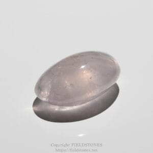 Close-up of a polished pinkish-purple oval cabochon (rose quartz) with a glossy surface on a pale background.