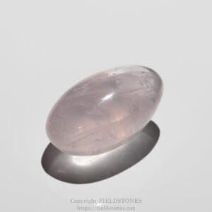 Smooth pink rose quartz oval gemstone resting on a white surface with a soft shadow.